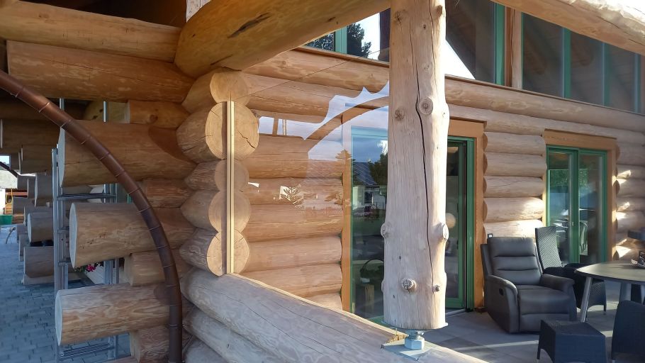 Glasscheibe als Windschutz an einem Naturstammhaus.