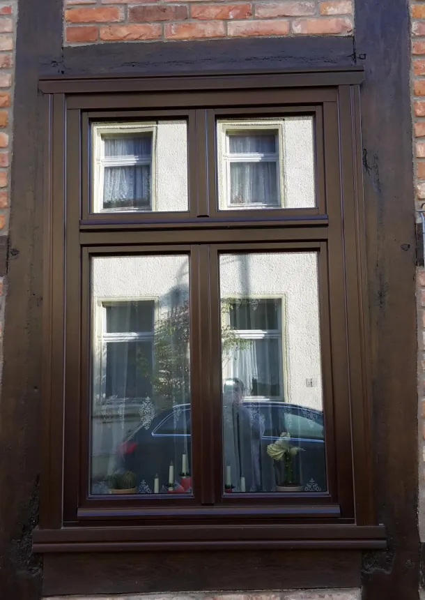 Gut gewartetes altes Holzfenster - Außenansicht in Rotklinker-Fachwerkfassade